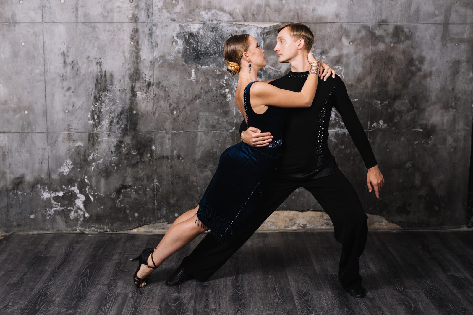 Pareja de baile mirándose en un abrazo cercano, la conexión que comparten la bachata y el bachazouk